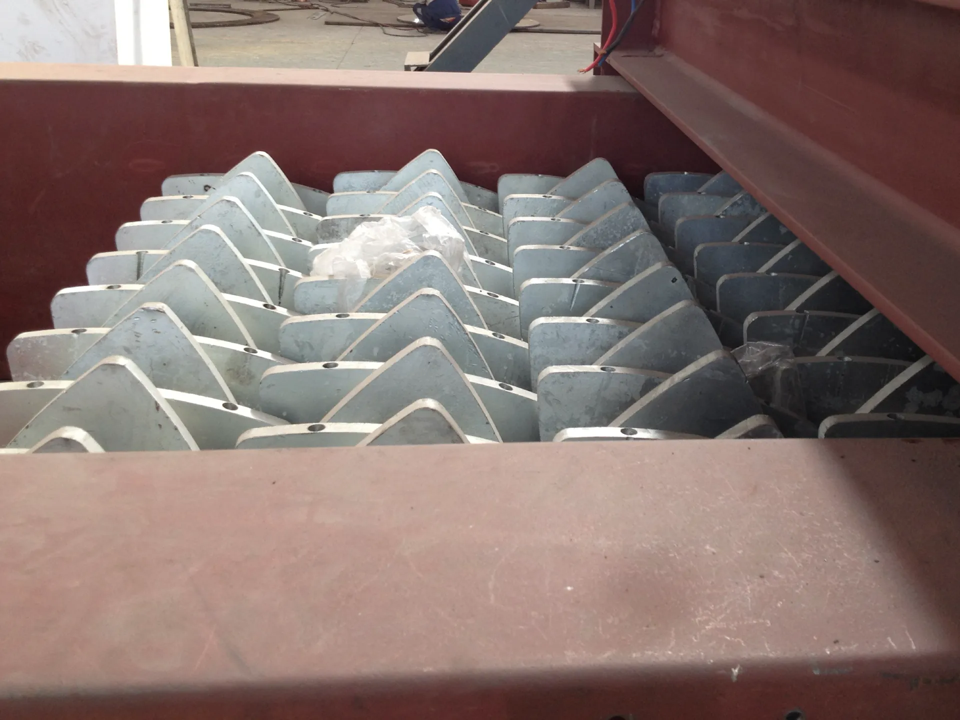 A close-up of an industrial disc screen, showing the interlocking, rotating star-shaped discs used for material size classification in a recycling line.